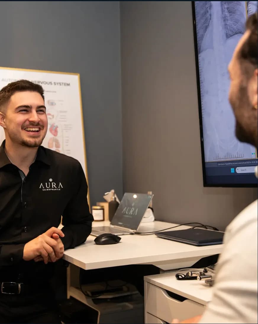 Dr Arthur Kaganovitch (Chiropractor) with a patient at Aura Chiropractic in Toorak
